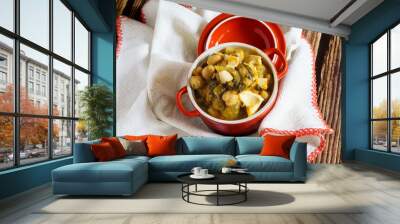 Chickpea stew with codfish and spinach, served in a red pot Wall mural