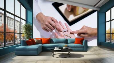 Close-up Of Female Doctor Showing Hearing Aid To Patient In Clinic Wall mural