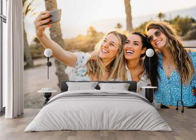 Group of three women friends making a selfie in a beach during a summer day. Friendship and holiday. Wall mural