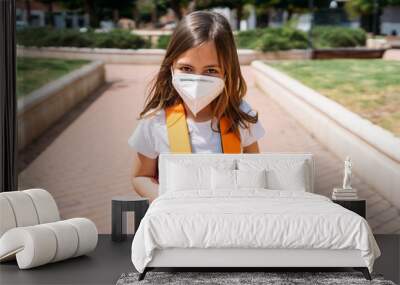 Little girl with mask in a park during the coronavirus pandemic Wall mural