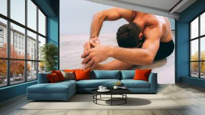 Yoga. Young man doing yoga exercise isolated on a white background. Yogi master workout on white urban studio. Yoga lifestyle healthy concept. Wall mural