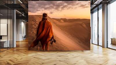 young woman from behind walking in sand dunes of maspalomas, gran canaria Wall mural