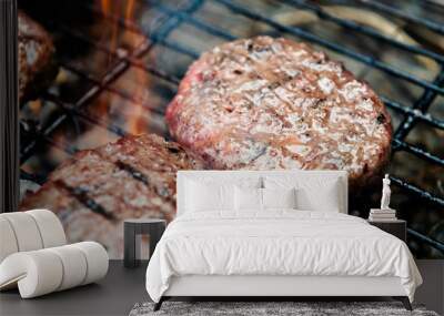 Burgers are cooking on grill with open flames Wall mural