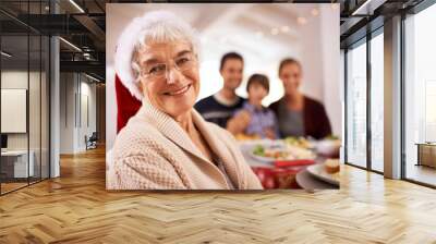 Christmas lunch with the family. A happy family sitting around the dinner table on Christmas day. Wall mural