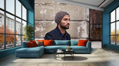 Fashion, wall or man in city thinking of casual clothes, style or edgy coat for winter outdoor outfit. Travel, cool model or stylish person walking in urban street in beanie or trendy jacket in Italy Wall mural