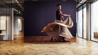 Feel the motion. Female contemporary dancer in a dramatic pose against dark background. Wall mural