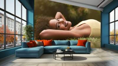 Happy, grass and portrait of black woman in park for relaxing, calm and peace in nature. Smile, garden and person laying outdoors for holiday, vacation and weekend for wellness, fresh air and joy Wall mural