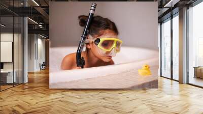 Like a duck to water. Shot of a cute little girl wearing snorkeling gear in the bath. Wall mural