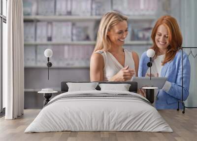 We get along so well. A cropped shot of two female colleagues working together in the office. Wall mural