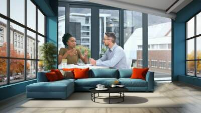 Business people, meeting and talking or planning in an office with city building background. A man and woman together at table for diversity, brainstorming and collaboration or partnership discussion Wall mural