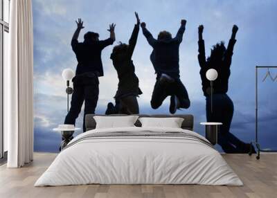 Celebrate life. Always. A group of young adults jumping in excitement against a twilight sky. Wall mural