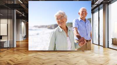 Elderly, couple and walk on beach for portrait on retirement vacation or anniversary to relax with love, care and commitment with support. Senior man, woman and together by ocean for peace on holiday Wall mural