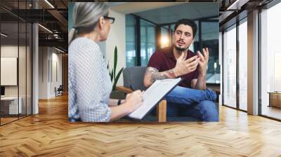 give your feelings a voice. shot of a young man having a therapeutic session with a psychologist. Wall mural