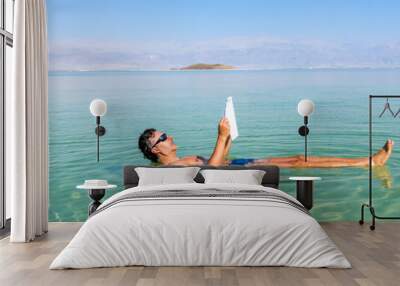 Man relaxing in nature.. View of Dead Sea coastline. Salt crystals at sunset. Texture of Dead sea. Salty sea shore. Web banner in panoramic view. Wall mural