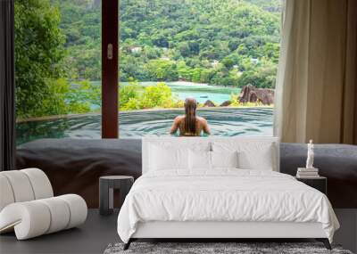 Paradise beach of Seychelles. view of woman's back admiring the sea. Wall mural