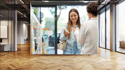 A female pharmacist talking with a female customer about a product Wall mural