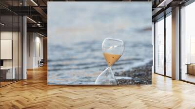 Hourglass on the beach at the seashore Wall mural