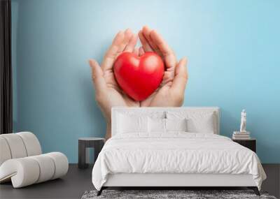 adult hands around red heart on light blue pastel background health care organ donation family life insurance world heart day world health day praying concept Wall mural