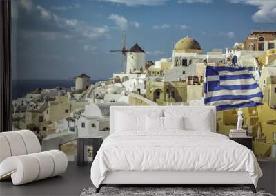 Village of Oia against greek waving flag, Santorini ,Greece Wall mural