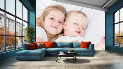 cute little girl hugs a sleeping baby brother Wall mural