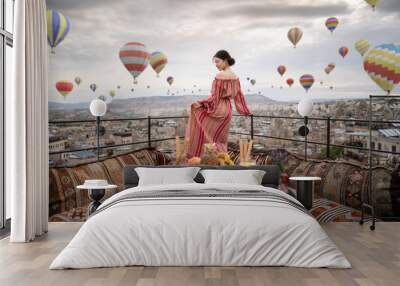 Happy women on rooftop of cave house enjoying of Goreme city panorama, Cappadocia Turkey. 3D balloons in the sky. Wall mural