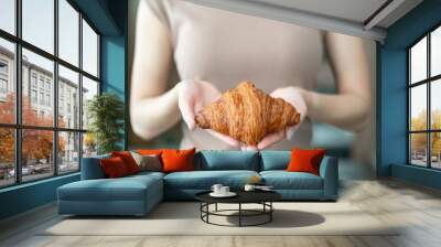 Woman hand serving baked crispy croissants. Wall mural