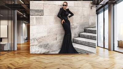 Elegant luxury evening fashion. Glamour, stylish elegant woman in black long evening gown dress is posing in the city outdoor. Female model in amazing long dress. Outdoor shoot. Vogue. Couture. Wall mural