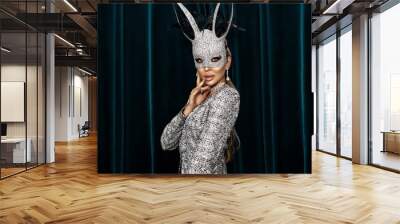 Sexy blonde woman dressed in Easter bunny mask and sexydress and is posing on dark velvet background. Easter bunny costume - Image. Wall mural