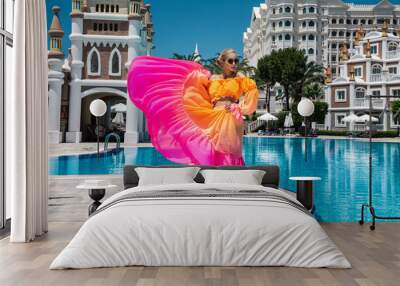 Summer fashion. Sexy fashion model. Glamour, stylish sexy blonde female model in summer elegant colorful dress near the pool. Travel model in a luxury hotel in the Turkish resort. Wall mural