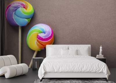 two rainbow color lollipops on brown background Wall mural