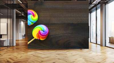 two rainbow colored lollipops on blue wooden background. Copy space. Top view. Wall mural