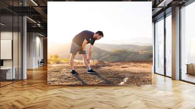 Brazilian mid-adult readies for a run, epitomizing fitness. Image conveys exercise preparation, inspiring a healthy life through sports. Set against a scenic backdrop with a beautiful sunset. Wall mural