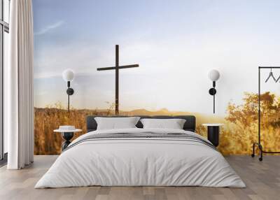 Silhouette of a Christian cross with sunset light in the background symbolizing  faith, forgiveness, salvation   resurrection of Jesus Christ. Wall mural