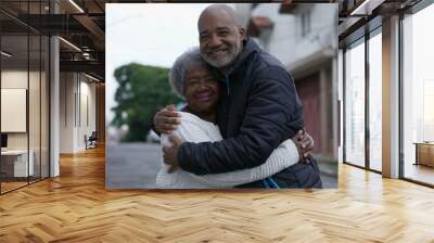 An adult son embracing elderly mother family love affection outside Wall mural