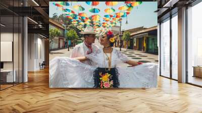 Dancers of typical Mexican dances from the region of Veracruz, Mexico, doing their performance in the street adorned with colored umbrellas. Wall mural