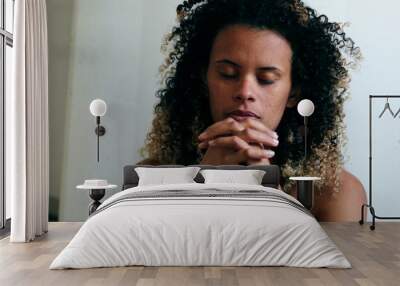 Depressed mixed race woman feeling praying with worry Wall mural