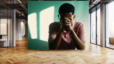 Dramatic young Brazilian man praying indoors having HOPE and FAITH. Spiritual person in prayer at home Wall mural