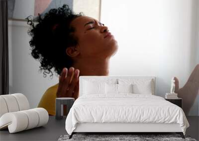 Evangelical young woman praying at home Wall mural