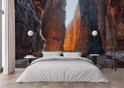 man with his back under some rocky mountain walls with a ray of sun coming in Wall mural