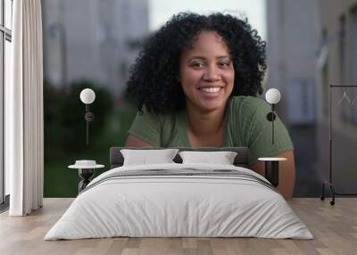 One happy young black latina woman smiling at camera. A Brazilian African American female person with curly hair closeup face Wall mural