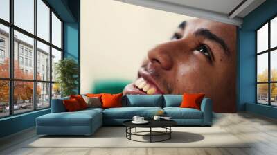 One young hispanic man opening eyes to sky smiling having HOPE and FAITH. Spiritual Brazilian guy feeling GRATEFUL Wall mural