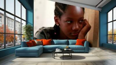 Pensive Black teen girl child thinking. Thoughtful sad depressed teenager adolescent girl Wall mural