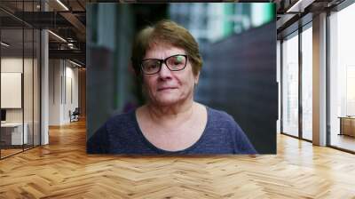 Portrait of a serious elderly woman looking at camera standing in residential corridor in Brazil. Close-up face of a stern senior lady Wall mural