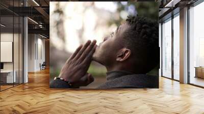 Religious young black man praying to God. African person looking up at sky with HOPE and FAITH2 Wall mural