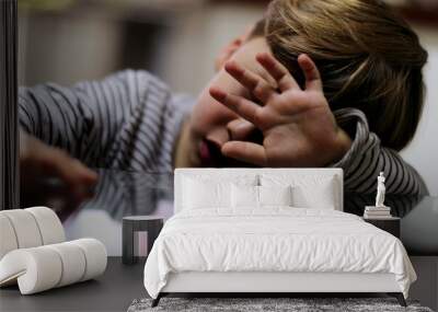 Sad small boy covering face with hand feeling sad and depressed Wall mural