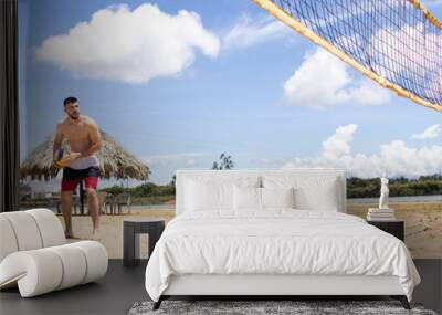 shirtless fit white man playing volleyball on a beach Wall mural