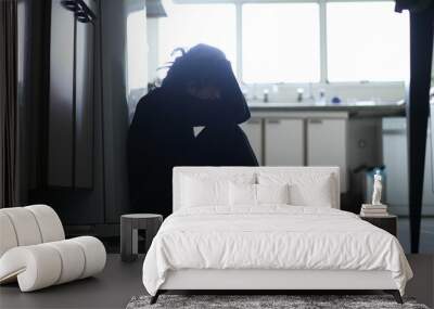 Silhouette of depressed woman sitting on kitchen floor. Sad person lonely and unhappy Wall mural