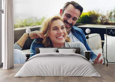 This is what you call a perfect holiday. Shot of an affectionate mature couple relaxing on couch outdoors while on holiday. Wall mural