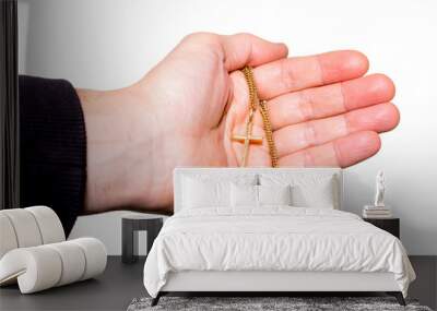 Hand holds a chain with gold crucifix Wall mural