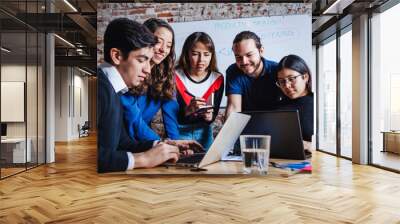 Group of young latin business people working with computer while spending time in the office in Mexico Wall mural